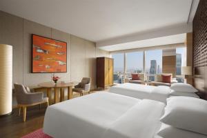 a hotel room with a bed and a living room at Park Hyatt Guangzhou in Guangzhou