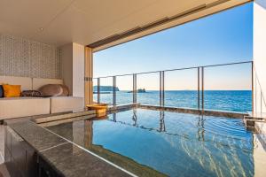 a swimming pool with a view of the ocean at さざね in Kyonan