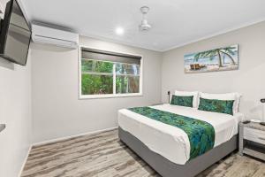 a white bedroom with a bed and a tv at Comfort Resort Blue Pacific in Mackay +105 photos