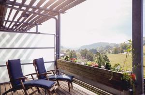 a balcony with two chairs and a view of a field at Das Sonnreich - Thermenhotel Loipersdorf in Loipersdorf bei Fürstenfeld