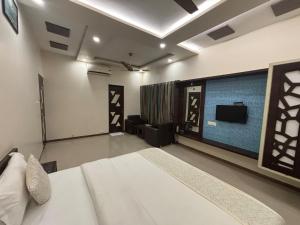 a bedroom with a bed and a flat screen tv at Hotel Anan Palace in Ābu Road