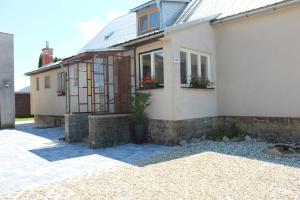 a house with two windows and a stone wall at Chalupa pod Lysou horou in Ostravice