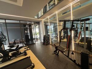 ein Fitnessstudio mit Laufbändern und Geräten in einem Raum in der Unterkunft Mehtan Hotel in Mae Sot