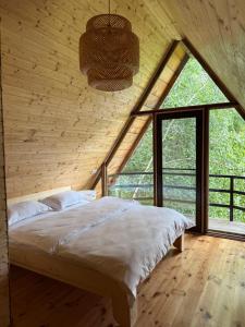 a bed in a room with a large window at Conacul lui Patrick in Poenari