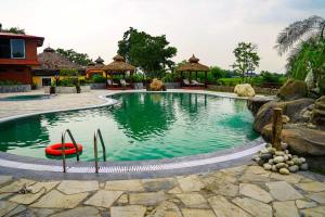 a pool at a resort with a red raft in it at Sapana Village Lodge in Sauraha
