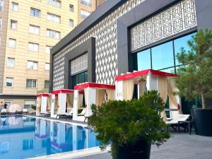 a hotel with a swimming pool in front of a building at Bishkek Park Apartments in Bishkek
