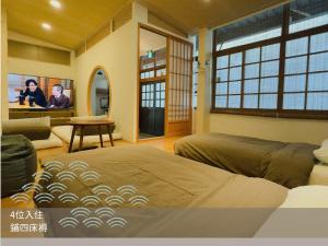 a bedroom with a bed and a living room at 錦小路平屋包棟民宿 Nishikikoji inn -寵物友善-國旅卡特約 - Switch- NETFLIX- 台南市民宿586號 in Tainan +22 photos