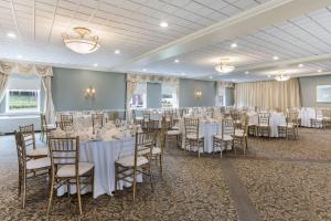 a banquet hall with white tables and chairs at Traditions Hotel & Spa Johnson City - Binghamton, an Ascend Collection Hotel in Johnson City