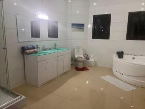 a white bathroom with a sink and a toilet at Akany Fitahiantsoa in Ivato +32 photos