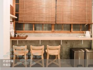 a kitchen with three chairs and a counter at 錦小路平屋包棟民宿 Nishikikoji inn -寵物友善-國旅卡特約 - Switch- NETFLIX- 台南市民宿586號 in Tainan