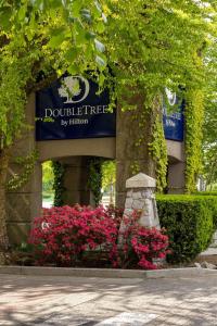 a building with a sign for a building with pink flowers at DoubleTree by Hilton North Vancouver in North Vancouver +122 photos