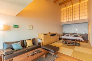 a living room with a couch and a bed at さざね in Kyonan +75 photos