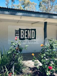 a sign on the side of a building with flowers at Ingenia Holidays Murray Bend in Koonoomoo
