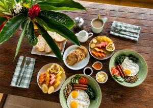 a wooden table with plates of breakfast food on it at Nirbana Retreat in Ahangama