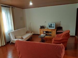 uma sala de estar com um sofá e uma televisão em Casa de Férias Morena Santa Cruz Madeira em Santa Cruz - Madeira