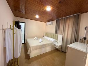 a bedroom with a bed with towels on it at RIVERSIDE Cottage in Martvili