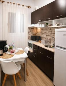 a kitchen with a table and a white refrigerator at Helena's house in Ermoupoli