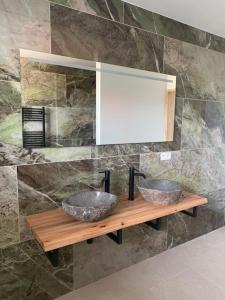a bathroom with two sinks on a wooden shelf at Villa Houtave in Zuienkerke +16 photos