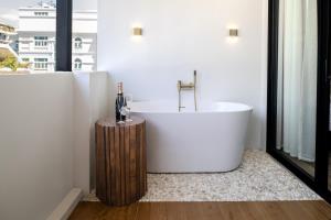 a bath tub in a bathroom with a window at Boutique hotel Axis Bangkok in Bangkok