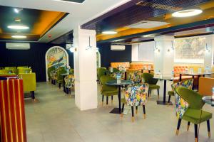 a restaurant with green chairs and tables and tablesktop at Sylhet Regency Ltd in Sylhet