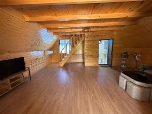 a large living room with wooden walls and wooden floors at RIVERSIDE Cottage in Martvili