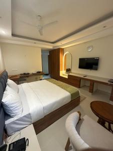 a bedroom with a large bed and a television at Hotel Mikado Palace in Gurgaon