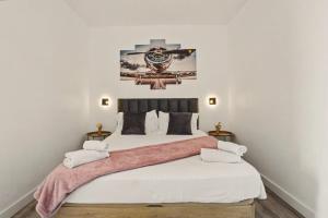 a bedroom with a large bed with white sheets at Lobo's House in Câmara de Lobos