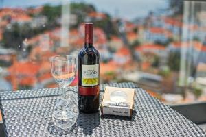 a bottle of wine and a glass on a table at Lobo's House in Câmara de Lobos