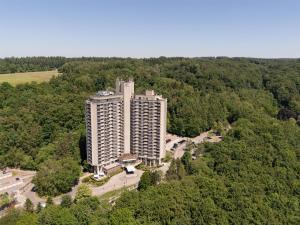 an aerial view of a tall building in the middle of a forest at DoubleTree by Hilton Luxembourg in Luxembourg