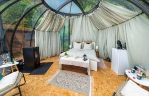 a bedroom with a bed and a tv in a tent at Entre Ciel et Rivière in Bouillon