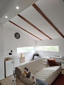 a living room with a couch and a clock on the ceiling at Vila Lokvanj in Gornja Vranjska