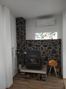 a fireplace in a room with a stone wall at Vila Lokvanj in Gornja Vranjska
