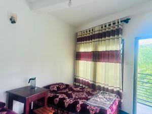 a bedroom with a bed and a table and a window at K K Kumar Guest in Norwood