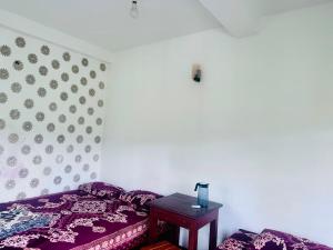 a bedroom with a purple bed and a table at K K Kumar Guest in Norwood