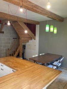 a dining room with a wooden table and a staircase at Charmant duplex 8 couchages 75 m2, terrasse 12 m2 dans village typique héraultais in Tourbes +24 photos