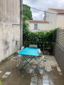 a blue table and two chairs on a patio at Charmant duplex 8 couchages 75 m2, terrasse 12 m2 dans village typique héraultais in Tourbes