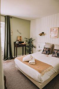 a bedroom with a large bed and a table at Ariane Hôtel in Vichy +26 photos
