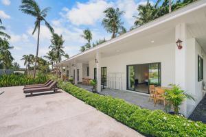 an exterior view of a house with palm trees at Anahata Resort in Lipa Noi