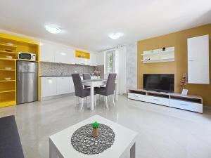 a living room with a table and a kitchen at Apartments Gorica 2 in Baška