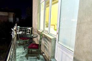 a balcony with a table and chairs and a window at Dilbar Guest House in Samarkand