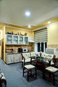 a living room with a table and a kitchen at Dilbar Guest House in Samarkand