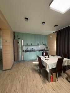 a kitchen with a table with chairs and a refrigerator at Relax Lux in Mykolaivka