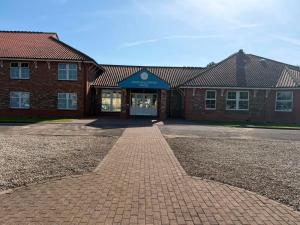 a brick building with a blue awning in front at Northallerton Motel in Northallerton