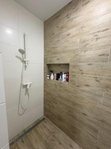 a shower in a bathroom with a wooden wall at Relax Lux in Mykolaivka +34 photos