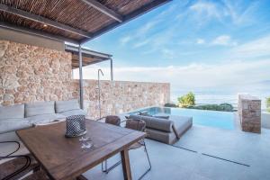 a living room with a couch and a table at AÁSHNA Suites and Residences in Vaia