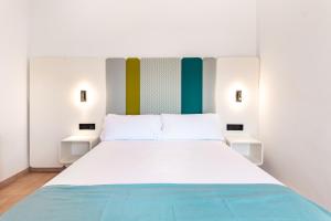 a bedroom with a large white bed with two tables at Smart Hotel Cabo Sur in Mojácar +94 photos