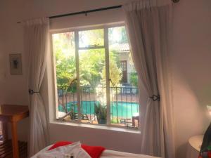 a bedroom with a window with a view of a pool at Blommenberg in Clanwilliam