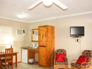 a living room with a television and a table and chairs at Blommenberg in Clanwilliam