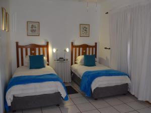 a bedroom with two beds with blue and white sheets at Blommenberg in Clanwilliam +60 photos