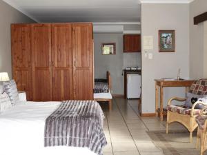 a bedroom with a bed and a kitchen with a table at Blommenberg in Clanwilliam